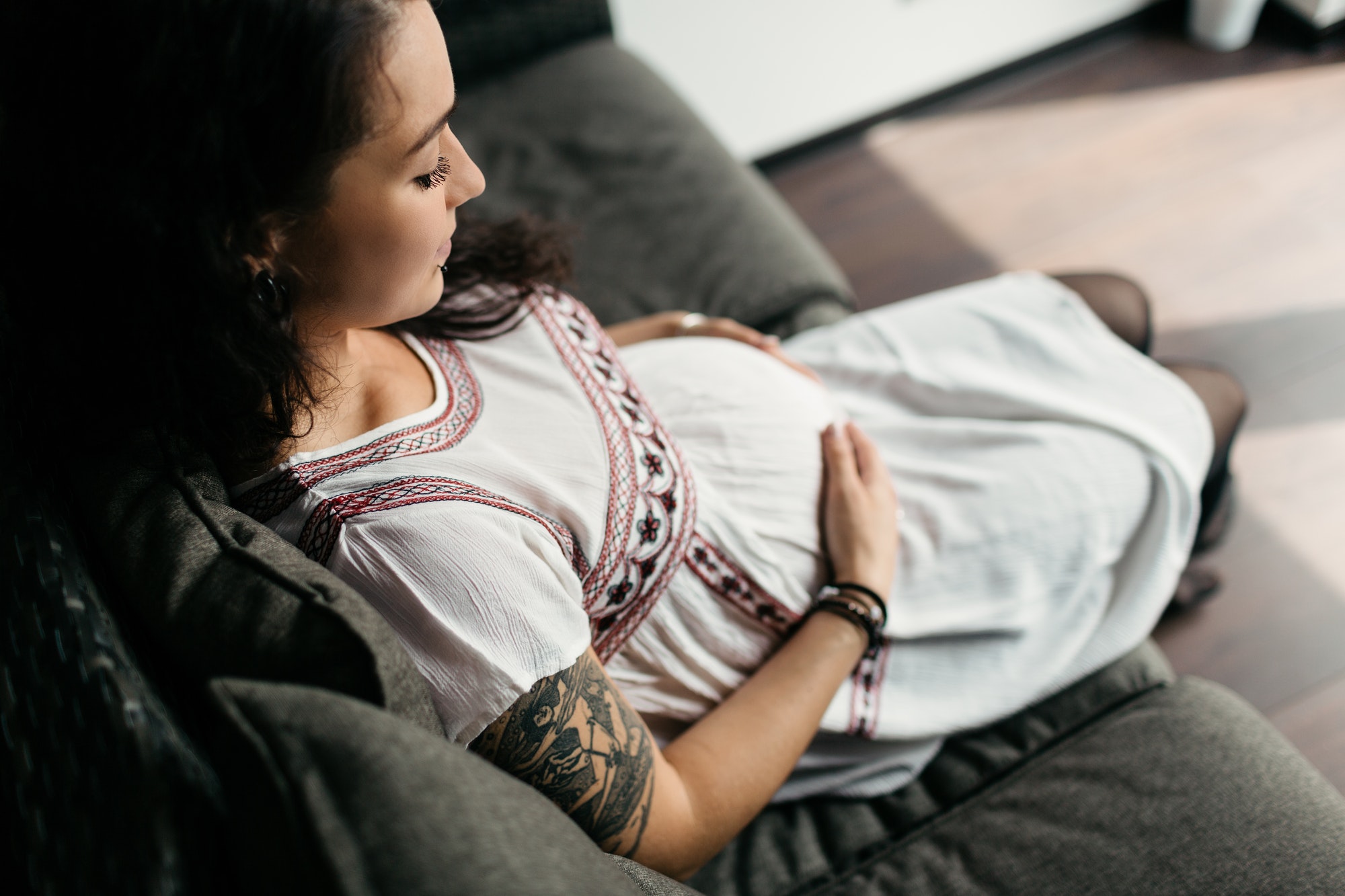 Portrait of a smiling pregnant woman touching her belly with love.