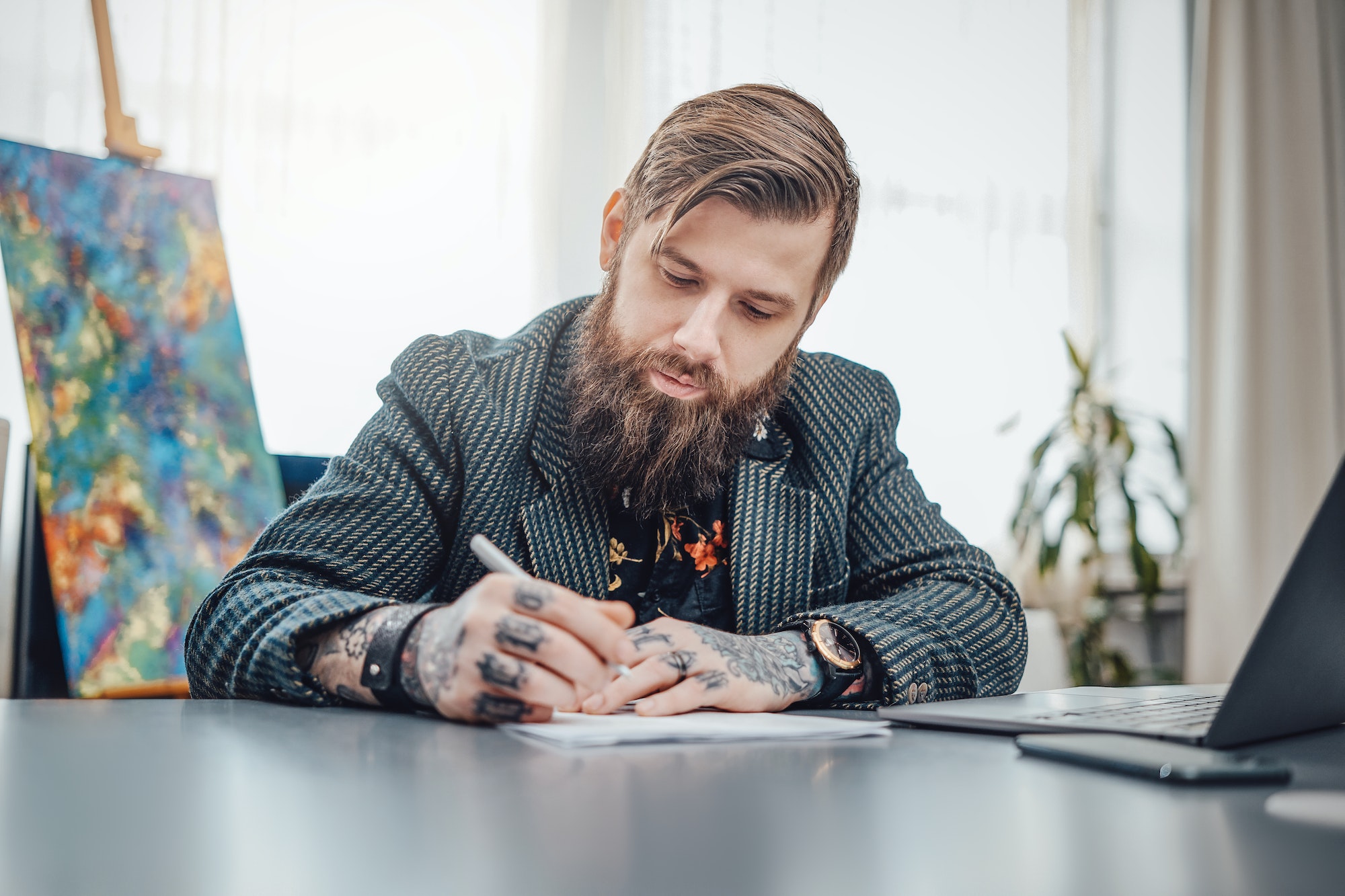 Bearded businessperson with tattoos and his remote work